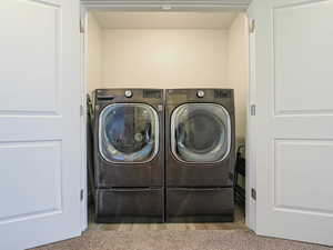 Laundry area with washer and dryer and carpet floors