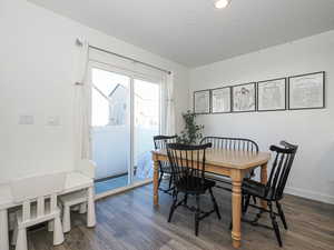 Dining area with dark wood-style flooring and a textured ceiling