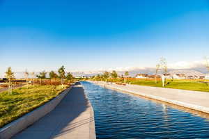 View of swimming pool featuring a yard and a water view