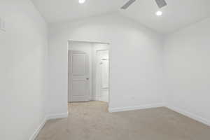 Unfurnished room featuring light colored carpet, recessed lighting, lofted ceiling, and a ceiling fan