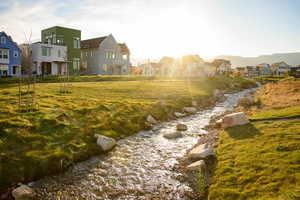 View of green lawn featuring a residential view and a water view