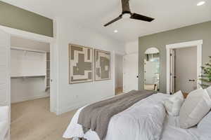 Carpeted bedroom featuring a walk in closet, recessed lighting, and arched walkways