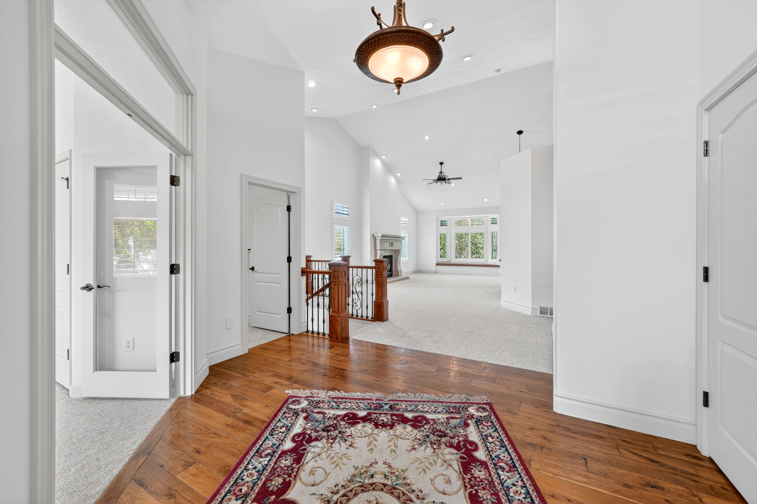 Foyer with wood-finish flooring transitioning to carpeted living areas
