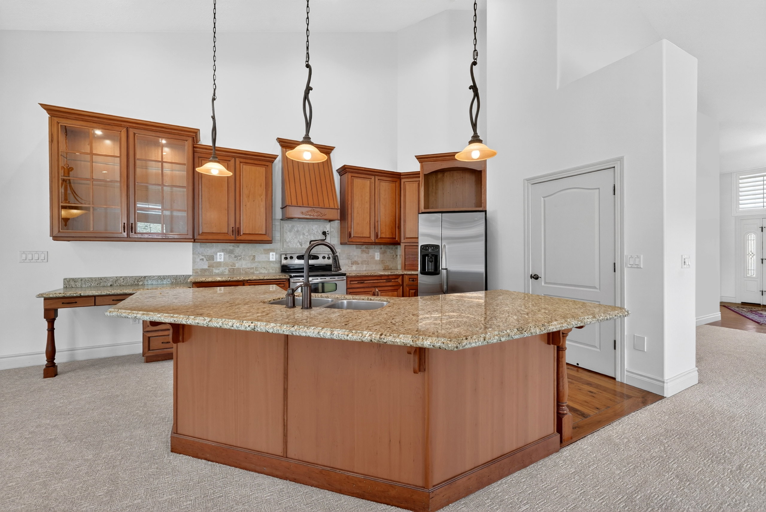 Kitchen featuring a large central island with a stone countertop, wood cabinetry, and stainless steel appliances