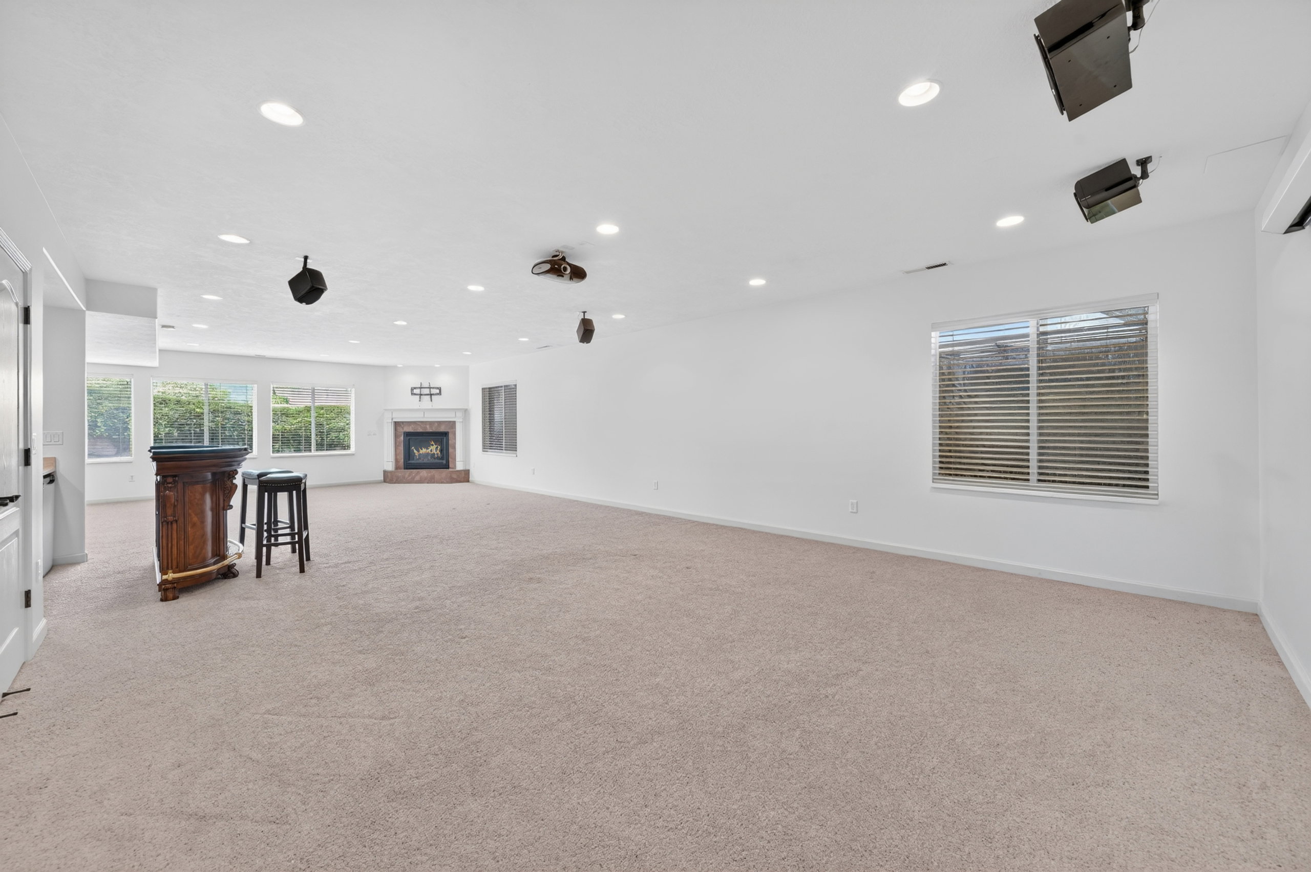 Spacious room featuring neutral carpet flooring, recessed lighting, and a brick fireplace
