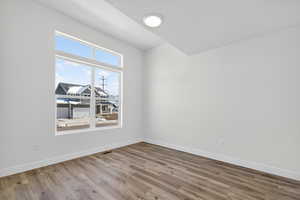 Spare room featuring baseboards and wood finished floors