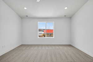 Unfurnished room with light carpet, a textured ceiling, and recessed lighting