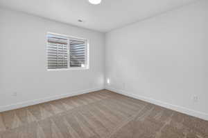 Carpeted spare room with baseboards