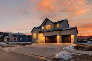 Modern farmhouse featuring board and batten siding, driveway, and a garage