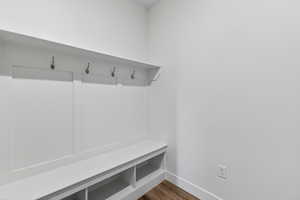 Mudroom featuring dark wood-style flooring and baseboards