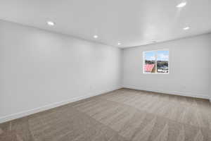 Unfurnished room with light colored carpet, recessed lighting, and a textured ceiling