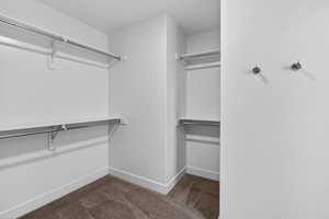 Walk in closet featuring dark colored carpet