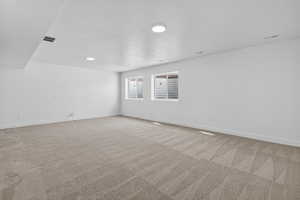 Empty room featuring light carpet and a textured ceiling