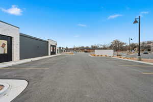 View of asphalt road with curbs and street lights