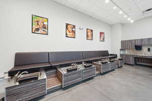 Living area with finished concrete flooring, a drop ceiling, and rail lighting