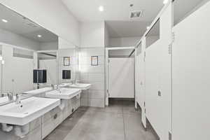 Bathroom featuring concrete floors, double vanity, and recessed lighting