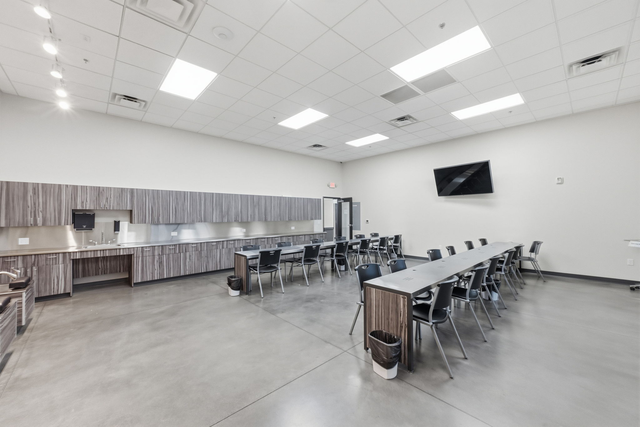 Dining room with finished concrete floors, a paneled ceiling, and a towering ceiling
