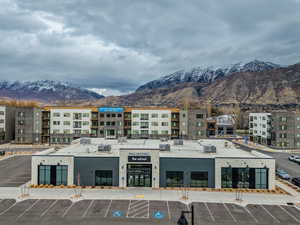 View of building exterior featuring a mountain view and uncovered parking