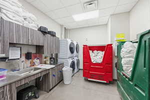 Laundry room featuring estacked washer and dryer and a paneled ceiling