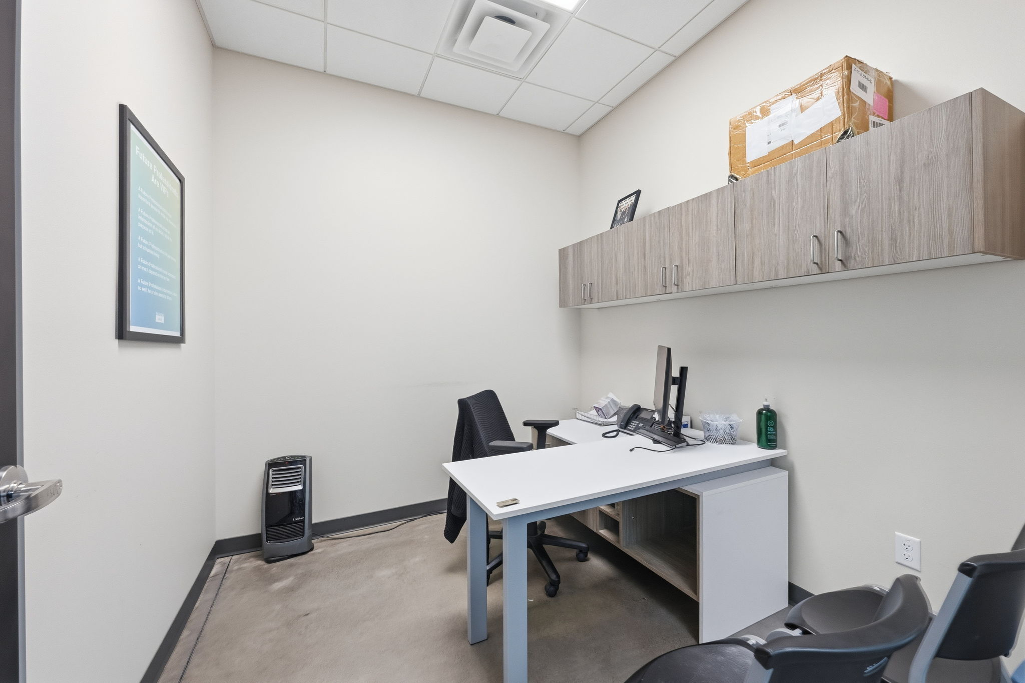 Home office featuring a drop ceiling and concrete flooring