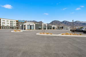 View of asphalt street featuring street lighting, a mountain view, and curbs