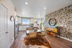 Dining area featuring wallpapered walls, dark wood-style flooring, a textured ceiling, and recessed lighting