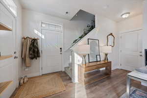 Entrance foyer with wood finished floors and stairs