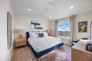 Carpeted bedroom featuring vaulted ceiling and recessed lighting