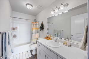 Full bathroom with shower / tub combo with curtain and vanity