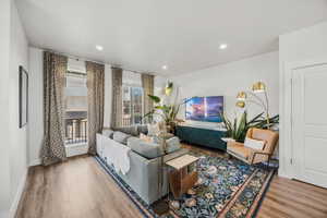 Living area with light wood finished floors and recessed lighting