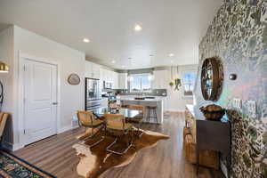 Dining area with a textured ceiling, dark wood-style flooring, and recessed lighting