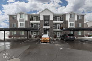 View of building exterior featuring covered parking