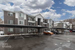 View of building exterior featuring covered parking and a residential view