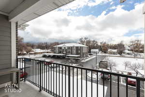 Snow covered back of property featuring a residential view