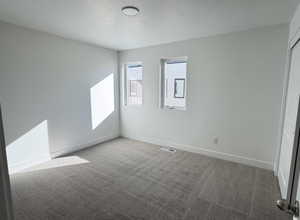 Unfurnished bedroom featuring light carpet and a closet