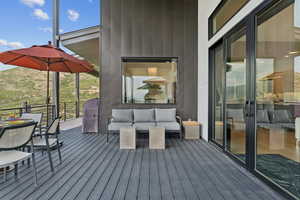 Wooden terrace with an outdoor hangout area, area for grilling, and outdoor dining area