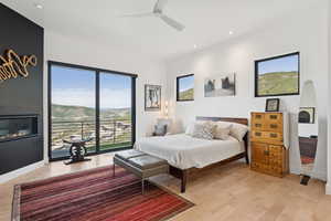 Bedroom featuring multiple windows, light wood finished floors, access to exterior, and recessed lighting