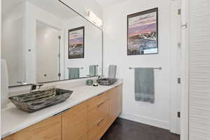 Bathroom featuring double vanity and finished concrete flooring