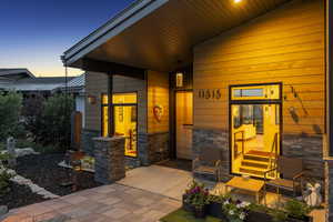 Exterior entry at dusk with stone siding