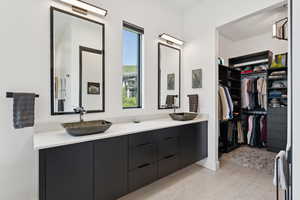 Bathroom with double vanity and a spacious closet