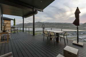Deck with outdoor dining area and a mountain view