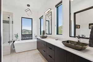 Full bath featuring a soaking tub, plenty of natural light, double vanity, and a shower stall
