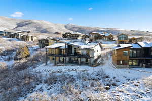 Rear view of property featuring a patio, stone siding, a residential view, and a mountain view