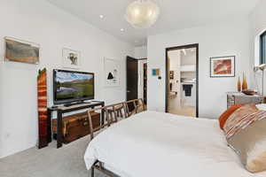 Bedroom with light colored carpet, recessed lighting, and ensuite bath