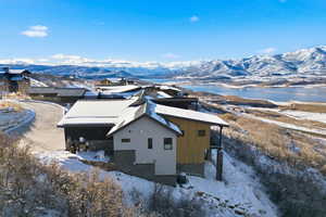 View of snow covered exterior featuring a mountain view and a patio