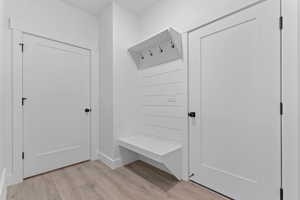 Mudroom featuring light wood-type flooring and baseboards
