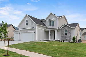 Modern farmhouse with board and batten siding, a front lawn, concrete driveway, and a porch