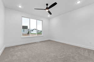 Empty room featuring light carpet, a ceiling fan, and recessed lighting