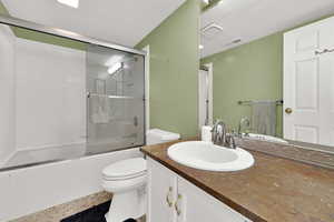Full bathroom with combined bath / shower with glass door, vanity, and tile patterned floors