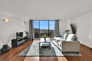 Open living room featuring LVP floors, abundant natural light, and balcony access